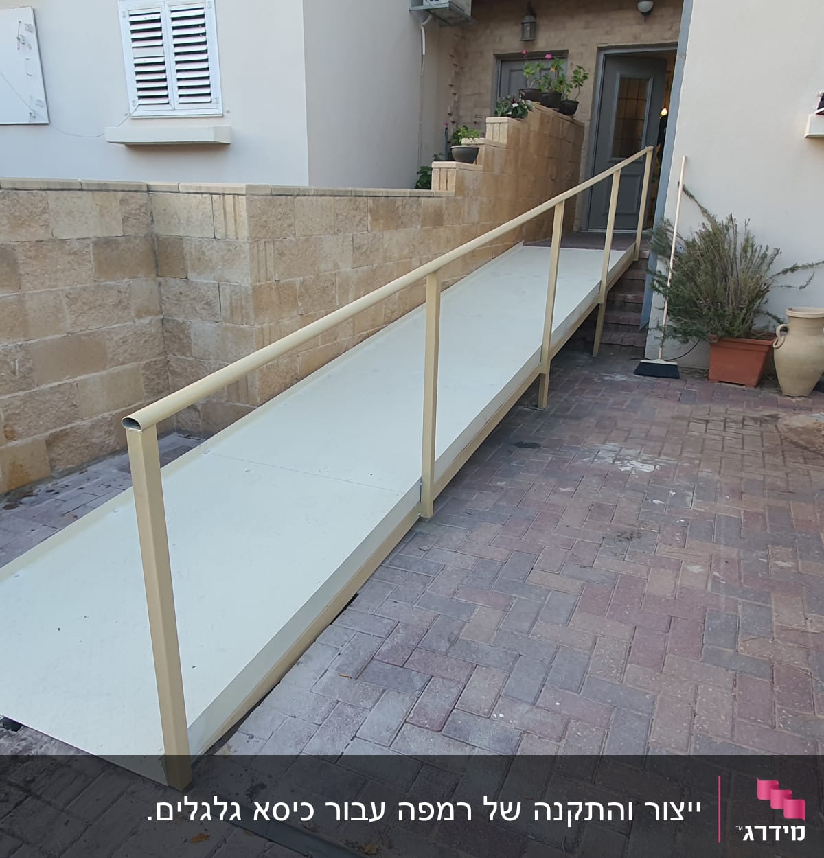 רמפה עם מעקה מתכת ליד קיר אבן